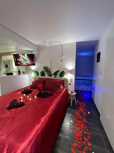 巴尔Beau gîte avec jacuzzi的一间卧室配有一张红色大床和红色毯子