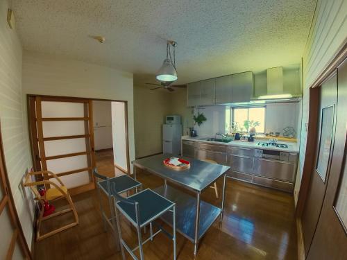 鹤冈市TSURUOKA GINZA 朙 sukima的一间带桌椅的厨房和一间带冰箱的厨房