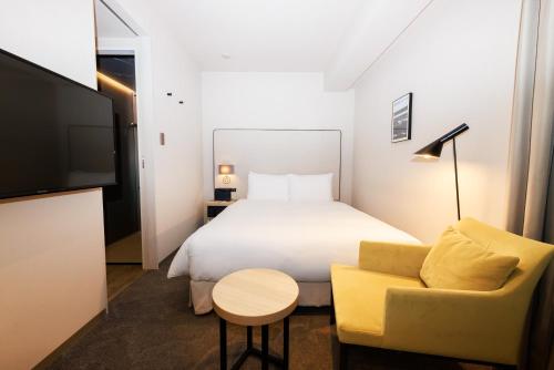 东京NOHGA HOTEL UENO TOKYO的酒店的客房 - 带一张床、椅子和电视