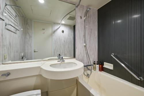 东京东京神保町芬迪别墅酒店的浴室配有盥洗盆、卫生间和浴缸。