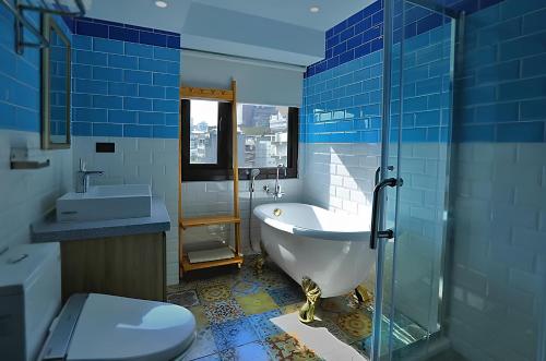 台北旅城驿镇的蓝色的浴室设有浴缸和卫生间。