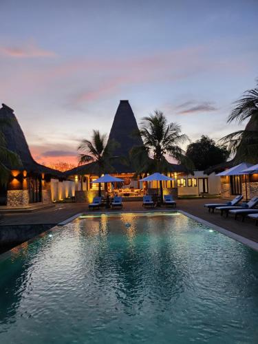 MaujawaKANDORA Luxury villas的黄昏时带椅子和遮阳伞的度假游泳池