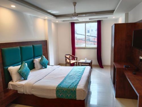 新德里Hotel Tark Plaza Near IGI Airport Delhi的一间卧室配有一张大床和电视