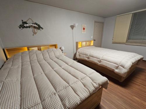 江陵市Happy Jumunjin House的一间卧室,配有两张床
