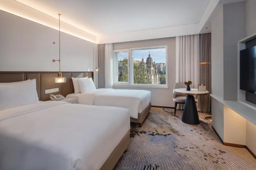 北京北京天伦王朝酒店的酒店客房设有两张床和窗户。