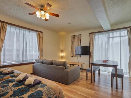 本部Yukurina Resort Okinawa的一间卧室配有一张床、一张沙发和一张桌子
