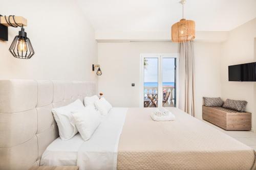 拉加纳斯Manthos Beachfront Apartments的卧室设有白色床,享有海景