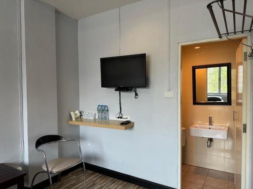 亚兰norndee hostel的一间带水槽和墙上电视的房间
