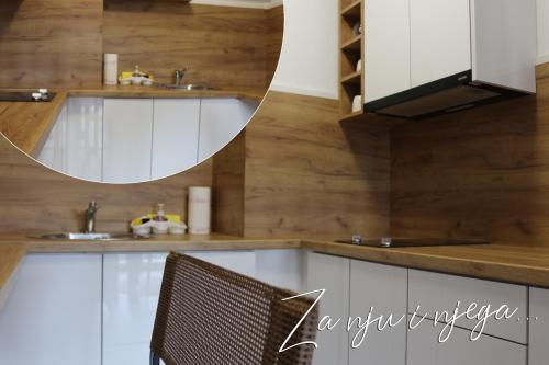 ŽiviniceWest Wing - Apartmani Živinice的厨房配有白色橱柜和镜子