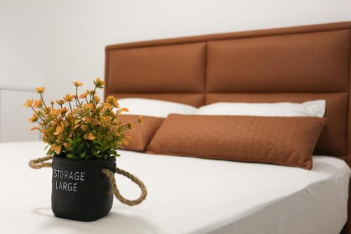 ŽiviniceWest Wing - Apartmani Živinice的坐在床边桌子上的花盆