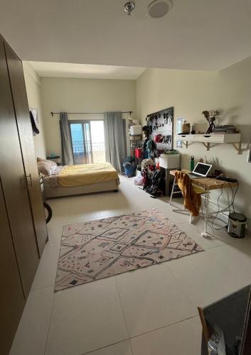 迪拜City Compass Living的客厅配有一张床,地板上铺有地毯