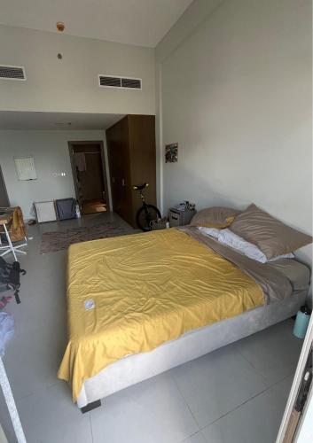 迪拜City Compass Living的一间卧室配有一张带黄色毯子的大床