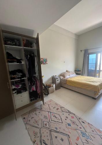 迪拜City Compass Living的卧室配有一张床,地板上铺有地毯
