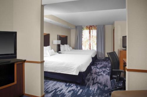 米利奇维尔米利奇维尔费尔菲尔德旅馆&套房酒店的配有一张床和一台平面电视的酒店客房