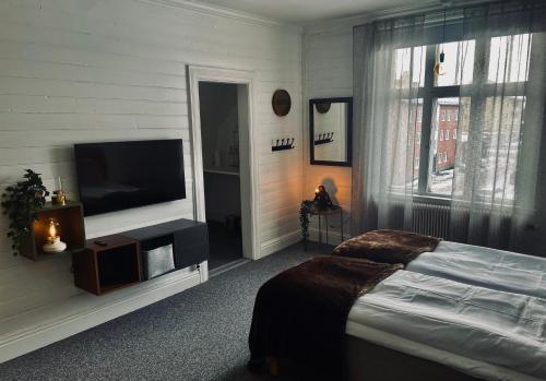 斯韦格Telegrafen Lägenhetshotell的一间卧室配有一张床和一台平面电视