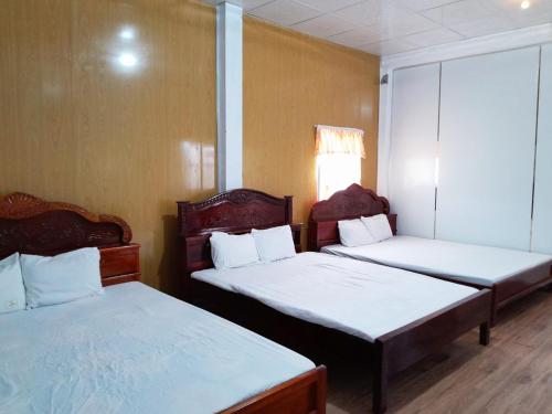 Rạch TàuHomestay Nguyễn Hùng的客房设有两张床和窗户。
