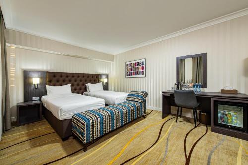 奇姆肯特Shymkent Grand Hotel的酒店客房设有两张床和电视。