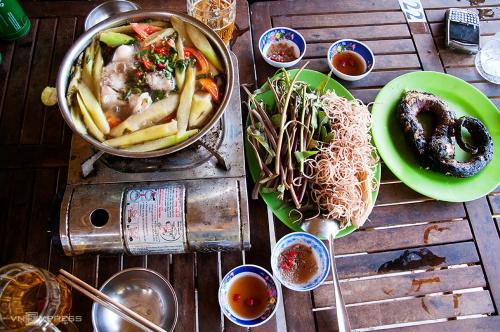 Rạch TàuHomestay Nguyễn Hùng的餐桌,饭盘和一碗面