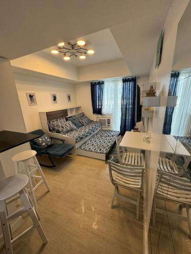 圣费尔南多Gellybean Homestay ( AZURE North Residence / Staycation)的客厅配有两张床和一张桌子