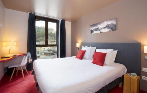 布里昂松SOWELL HOTELS Le Parc & Spa的一间设有大床和窗户的酒店客房