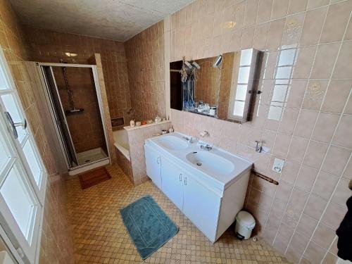Savignac-de-DurasMaison Les Bardots的浴室配有盥洗盆、镜子和浴缸