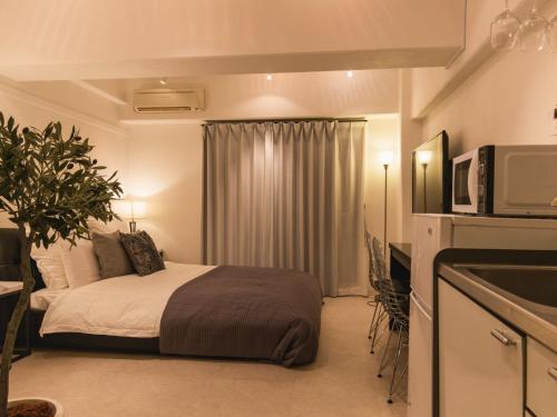 那霸Aiwa Mansion / Vacation STAY 80384的酒店客房带一张床和一台微波炉