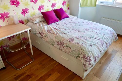 IcklefordAnna's House的一间卧室配有一张带紫色和粉色枕头的床