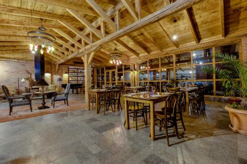 克瓦雷利Isev Kvareli的餐厅设有木制天花板和桌椅