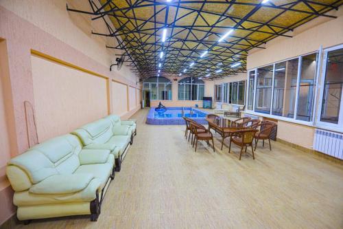 YalanghochСабзавот Давр Дача的大型客房设有沙发、桌子和游泳池。