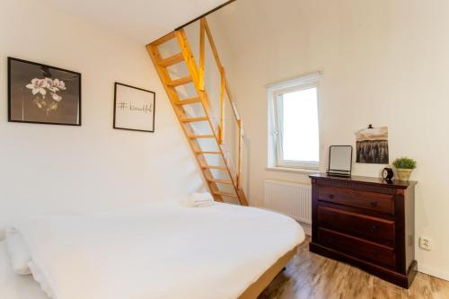 艾斯登Stijlvolle @ luxe vrijstaande woning Maastricht的一间卧室,卧室配有床和靠窗的梯子