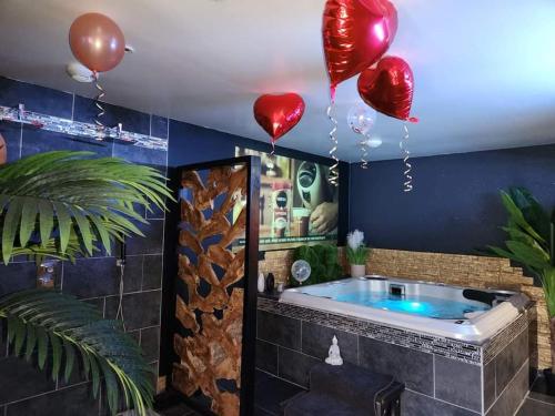 讷莱米讷Beauty spa loveroom的一个带气球的房间的按摩浴缸