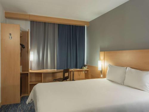 萨马拉萨马拉宜必思酒店的酒店客房设有一张大床和一张书桌。