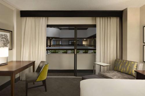 萨凡纳凯悦萨凡纳酒店的一间带书桌的客厅和一间带桌子的客厅。