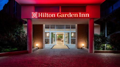 博洛尼亚Hilton Garden Inn Bologna North的一座建筑,上面标有读希林森花园旅馆