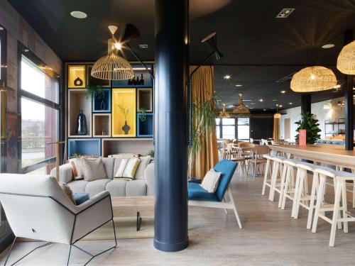 Dechyibis Douai Dechy的一间带沙发和椅子的餐厅和一间酒吧