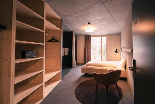 图西斯Story Thusis的一间卧室,卧室内配有一张床和一把椅子