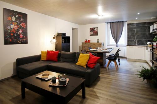 阿尔布瓦L'Atelier 57 - Votre meublé authentique !的客厅配有沙发和桌子