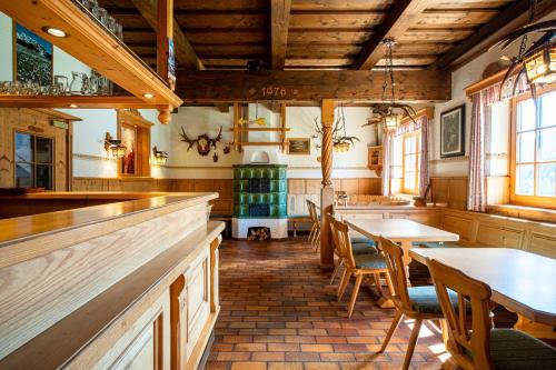 上柯尼希山麓米尔巴赫Mittereggalm的一间带桌椅的餐厅和一间酒吧