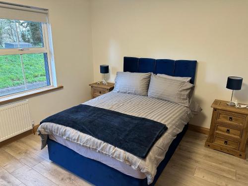 ClogherMac's Cottage的卧室里一张带蓝色床头板的床