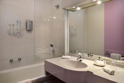 卢瓦尔河畔普伊普宜瑞莱之家酒店的一间带水槽、浴缸和镜子的浴室