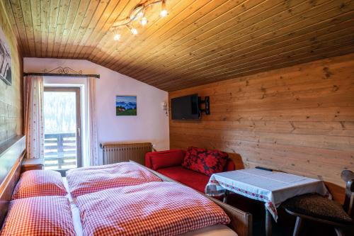 上柯尼希山麓米尔巴赫Mittereggalm的一间卧室配有一张床和一张红色的沙发