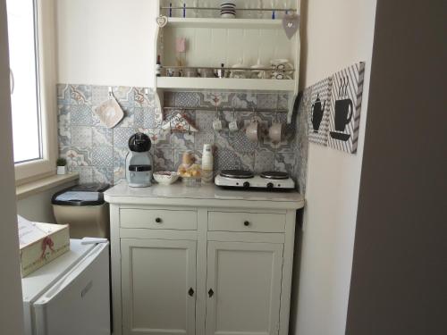 莫诺波利Diamantea的小厨房配有白色橱柜和冰箱。