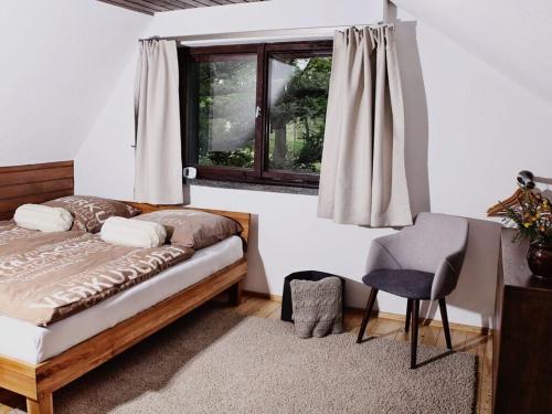 DrebachDrebach Modern retreat的卧室配有床、椅子和窗户。