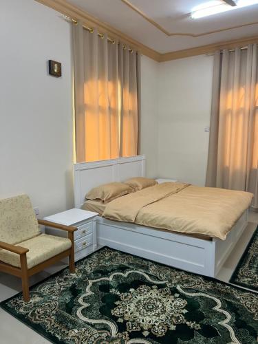 苏尔Orchid sur guest house的一间卧室配有一张床和一把椅子