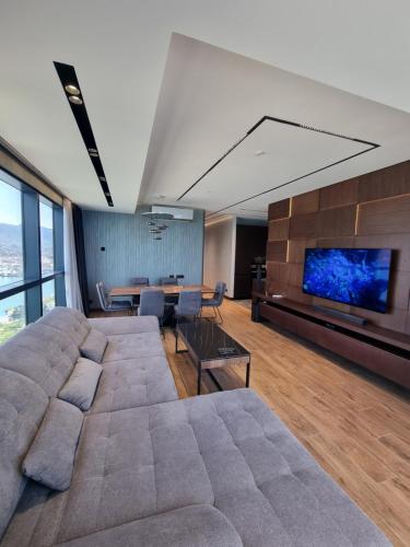 巴统Premium apartment in Porta Batumi Tower的客厅设有大沙发和电视