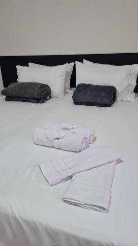 尼泰罗伊Residencial do Centro的白色的床、白色毛巾和枕头