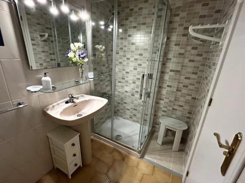 奥里韦拉斯科斯塔Apartamento Vilandra de Cabo Roig的一间带水槽和玻璃淋浴的浴室