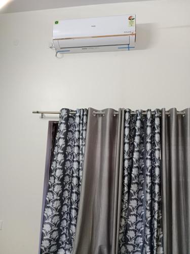 马图拉Hari Sharnam Home Stay的一间配有空调的窗帘杆的房间