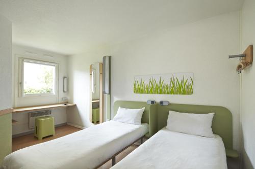 布鲁瓦布卢瓦中心宜必思快捷酒店的客房设有两张床和窗户。