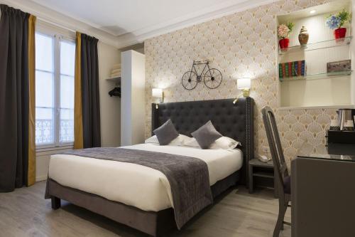 巴黎普莱公寓的卧室配有一张床和一张桌子,墙上挂着自行车